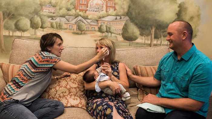 Birth mom wipes the tears of adoptive mom. Copyright Sara Liz Photography.