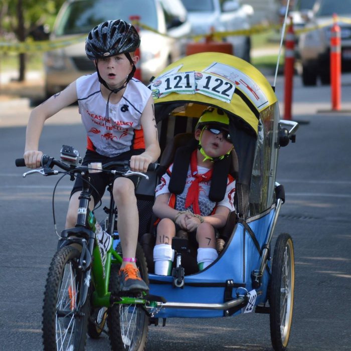 Noah and Lucas Aldrich compete on bike in a triathlon