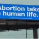 screenshot from video, billboard, abortion